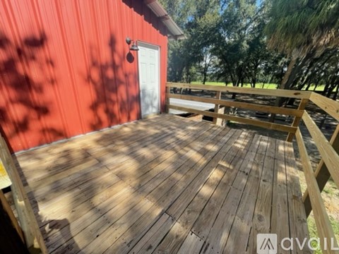 A wooden deck with a red building in the background.