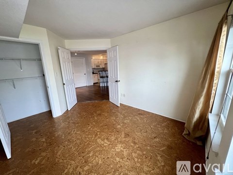 A room with a carpeted floor and a doorway leading to another room.