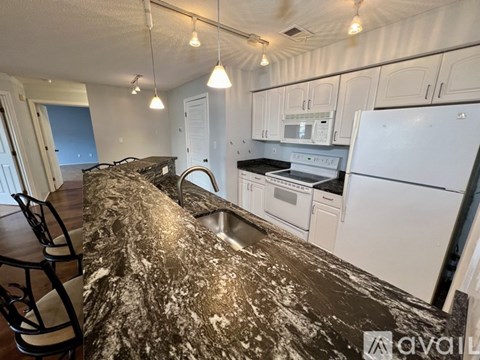 A kitchen with a white refrigerator and white cabinets.
