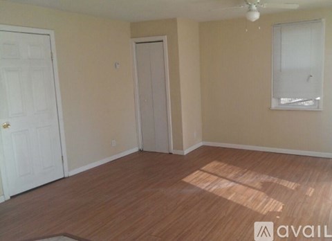 A room with wooden flooring and a ceiling fan.