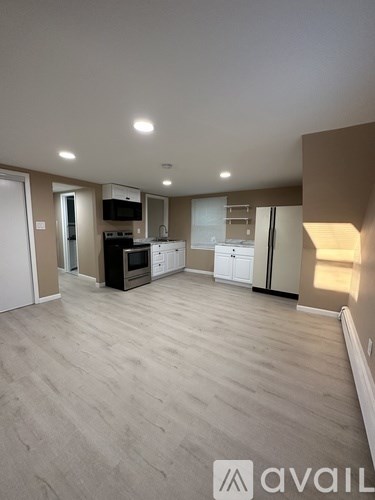 A spacious kitchen with wooden flooring and modern appliances.