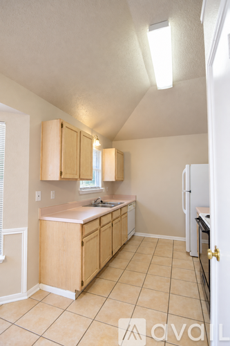A kitchen with wooden cabinets and a white refrigerator.