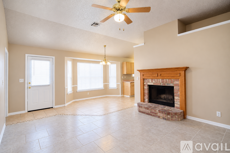A living room with a fireplace and a ceiling fan.