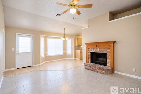 A living room with a fireplace and a ceiling fan.