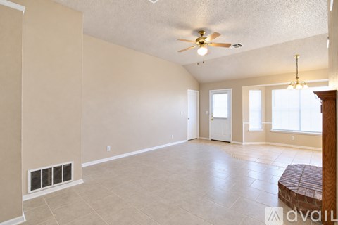 A spacious room with a ceiling fan and a window.
