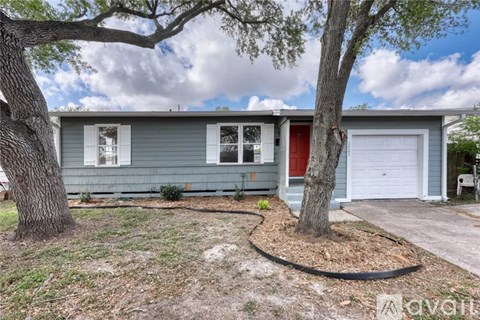 A house with a red door and a tree in front.