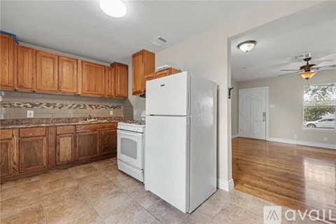 A kitchen with wooden cabinets and a white refrigerator.