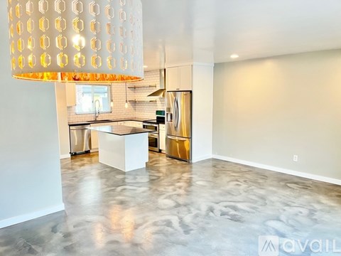 A modern living room with a large white lamp and a grey floor.