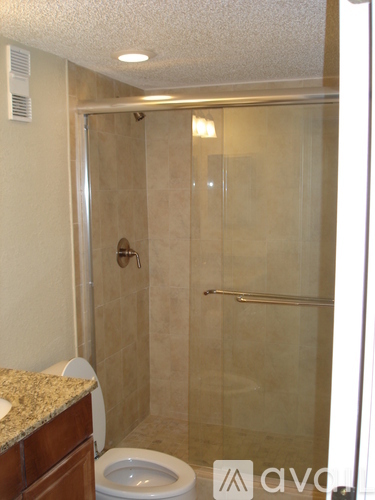 A bathroom with a toilet, sink, and walk-in shower.