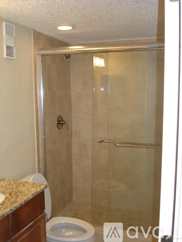 A bathroom with a toilet, sink, and walk-in shower.