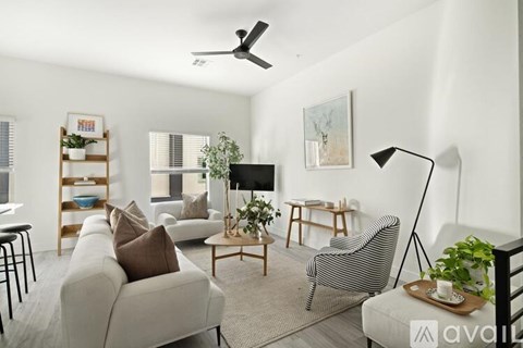 A living room with a striped chair and a flat screen TV.