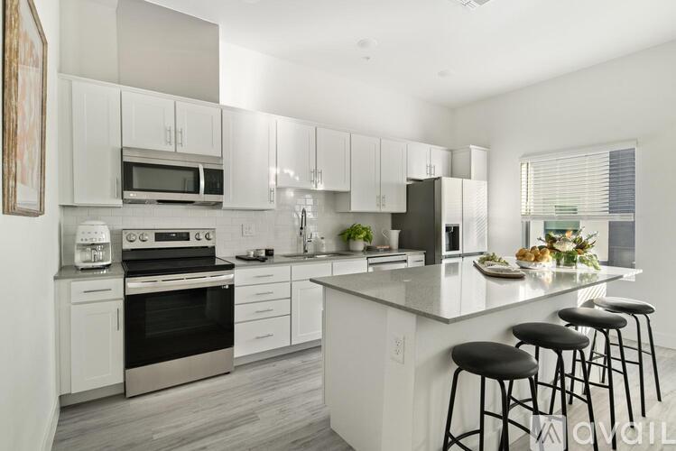 A modern kitchen with white cabinets and a large island.