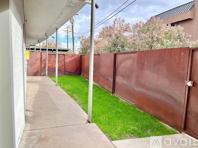 A brown fence runs along the side of a building.