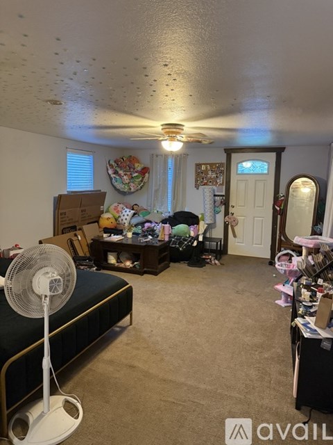 A room with a fan and a bed.