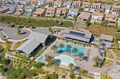 A bird's eye view of a resort with a swimming pool and palm trees.