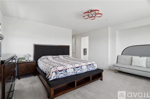 A bedroom with a large bed and a couch.