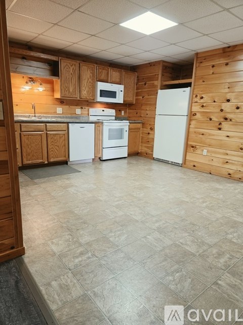 A kitchen with tile flooring and wooden cabinets.
