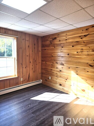 A room with wooden walls and a window.