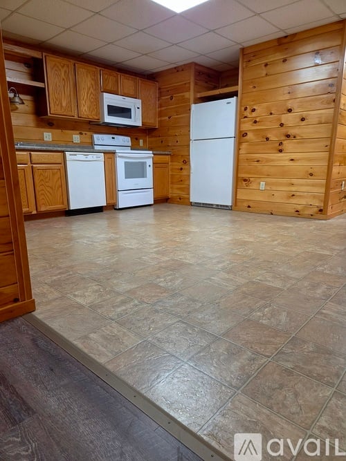 A kitchen with wooden cabinets and a white refrigerator.