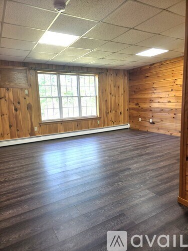 A room with wooden walls and a window.