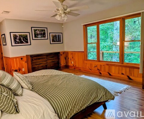A bedroom with a large bed and a ceiling fan.