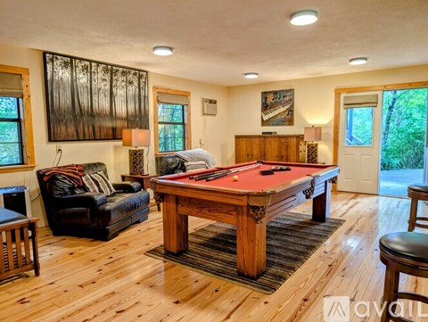 A room with a pool table and a couch.