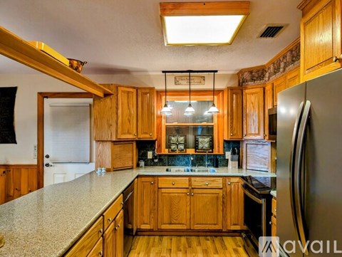 A kitchen with wooden cabinets and a granite countertop.