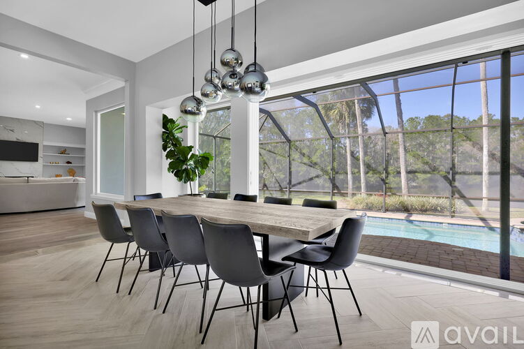 A modern dining room with a long table and chairs.