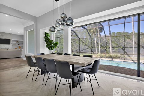 A modern dining room with a long table and chairs.