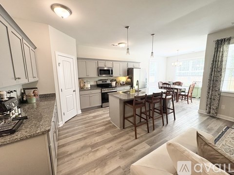 A kitchen with a dining table and chairs.