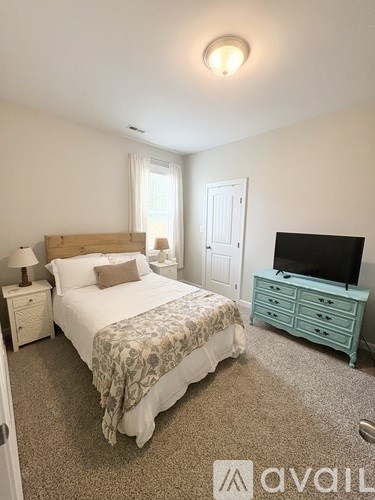 A bedroom with a bed, nightstand, and television.