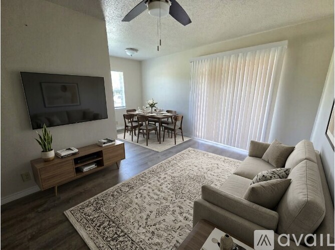 A living room with a grey couch and a wooden entertainment unit.