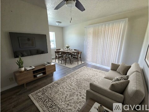 A living room with a grey couch and a wooden entertainment unit.