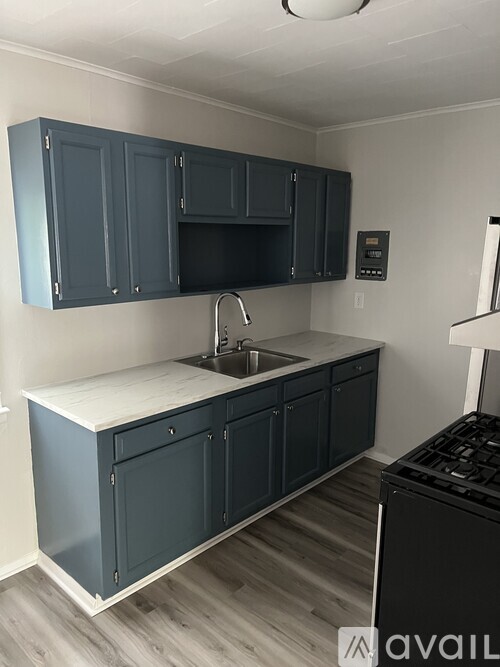 A kitchen with dark blue cabinets and a white countertop.