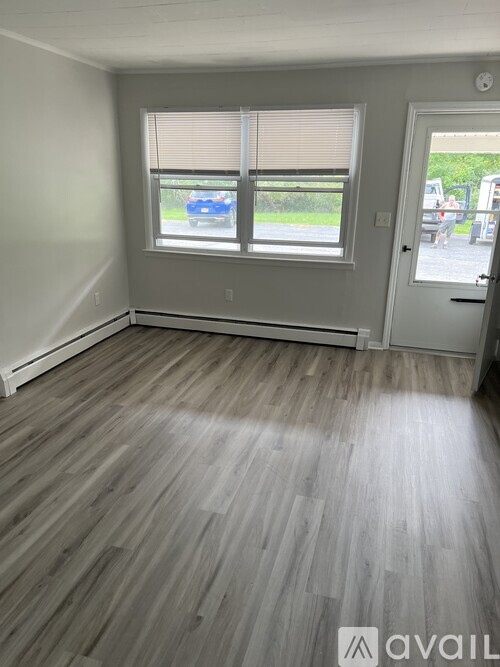 A room with a window and wooden flooring.