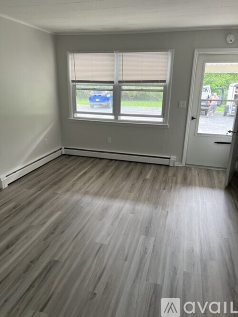 A room with a window and wooden flooring.