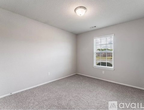 A room with a window and carpeted floor.
