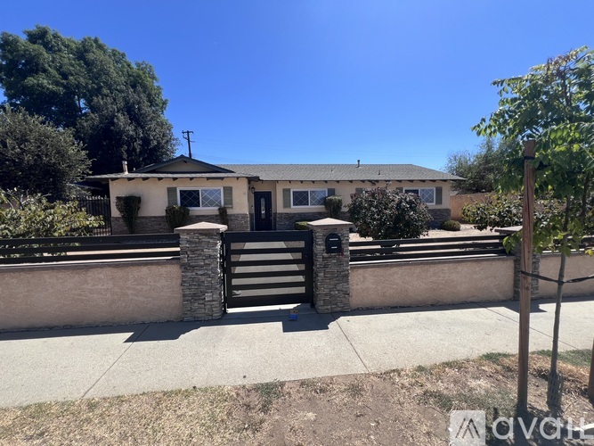 A house with a brown fence and a mailbox on it.