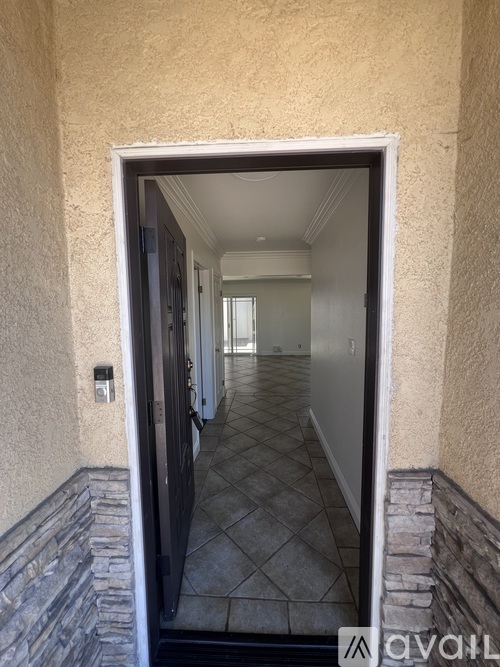 A hallway with a tiled floor and a stone ledge on the wall.