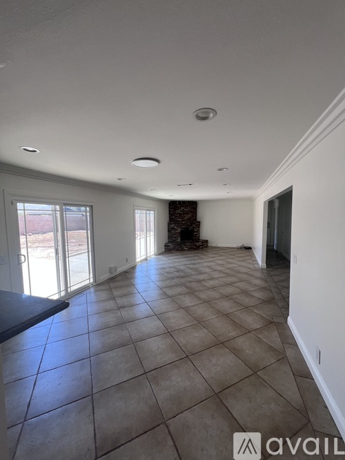 A spacious room with tiled flooring and a large window.