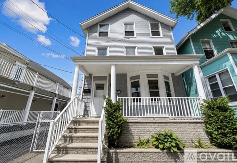 A house with a grey facade and a white porch.
