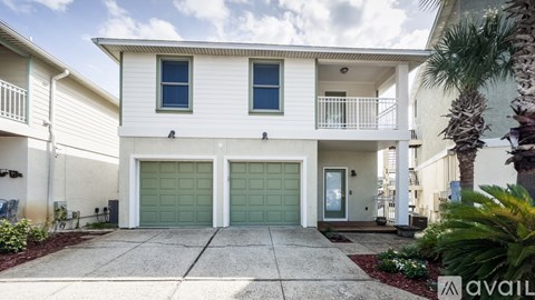 A two-story house with a garage and a balcony.