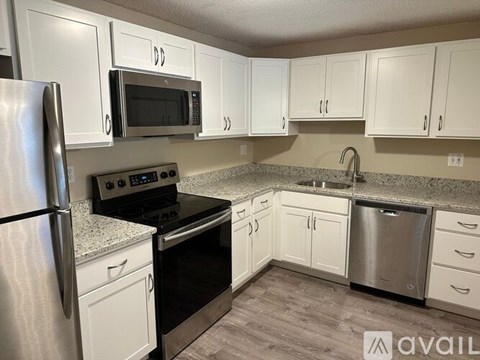 A kitchen with white cabinets and stainless steel appliances.