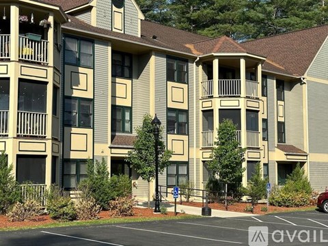 A large apartment complex with a parking lot in front.