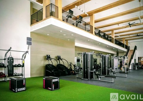 A gym with a variety of equipment including a punching bag, a weight bench, and a treadmill.