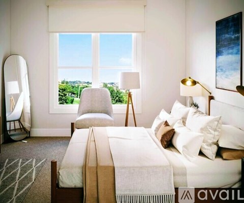 A bedroom with a large bed and a view of the outdoors through a window.