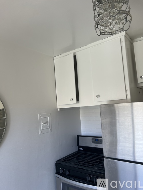 A kitchen with a stove and a cabinet above it.
