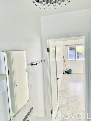 A white bathroom with a shower and a mop.