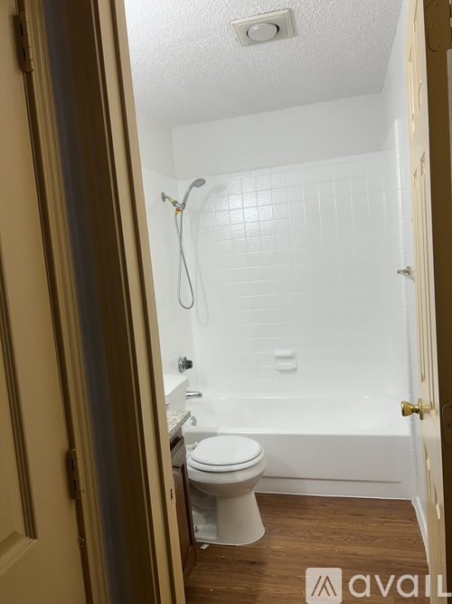A bathroom with a toilet, tub, and shower.