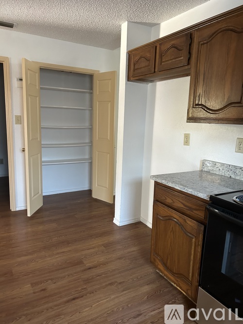 A kitchen with wooden cabinets and a black stove top oven.